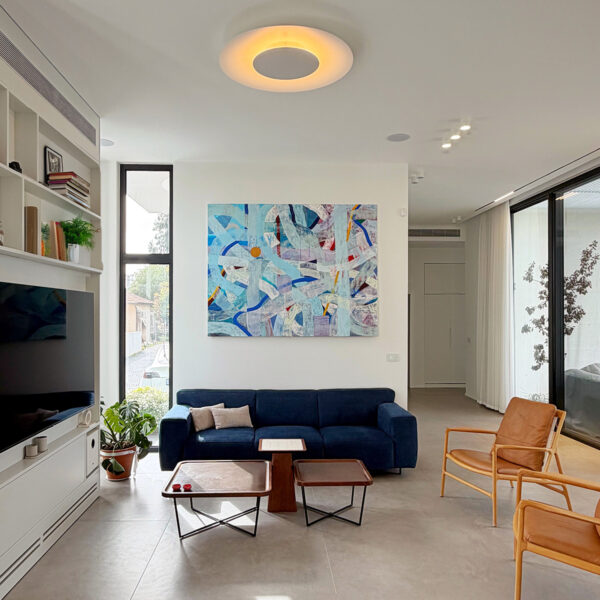 ספה כחולה במרכז הסלון בעיצוב בתים פרטיים